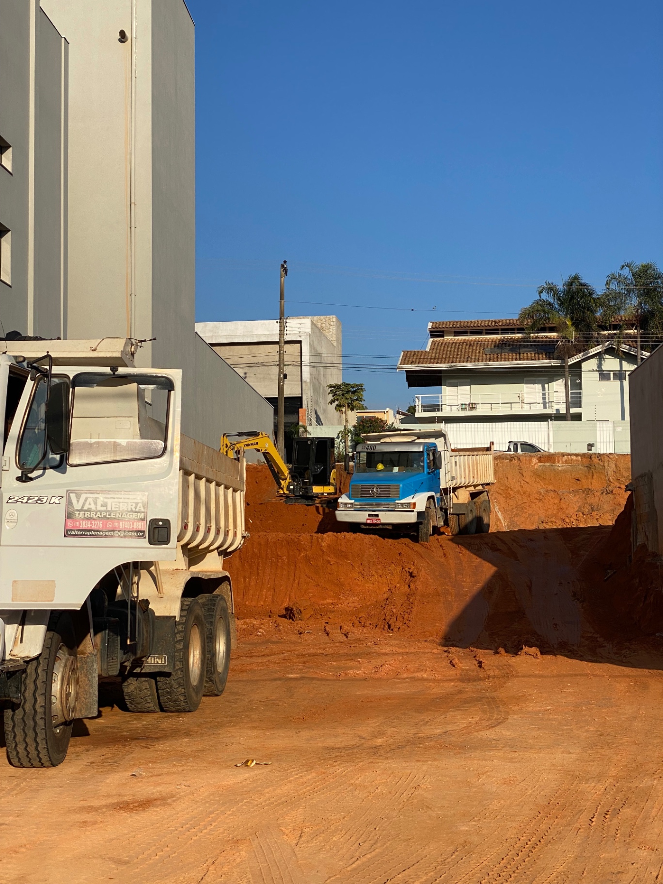 Frota própria da Valterras Terraplenagem: retroescavadeira e caminhão basculante